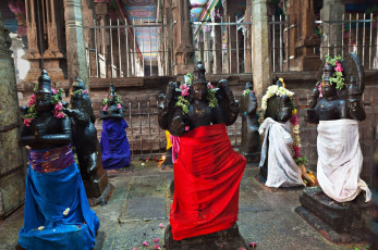 Worshipers decorate ancient figures of deities at the Meenakshi temple, Madurai with flowers and colourful clothes © saiko3p
