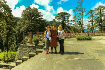 Foreign tourists pose with a Bhutanese gentleman in traditional clothes at the Druk Wangyal Lhakhang Temple at the Dochula Pass, Bhutan