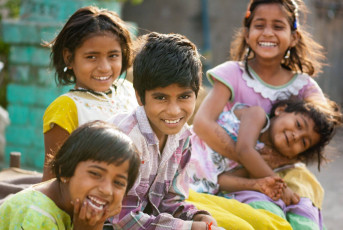 A cheerful picture of childhood friends, giggling and laughing while posing for the camera in a city of India © Karves