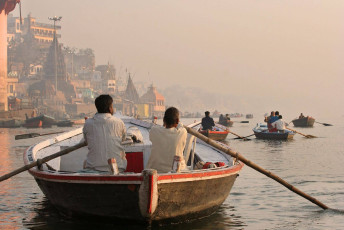 A beautiful view of an early morning boat trip with two riders on the River Ganges in Varanasi, India © AMA - <i>Boat-ride-ganges-varanasi Cultural North India Tour</i>