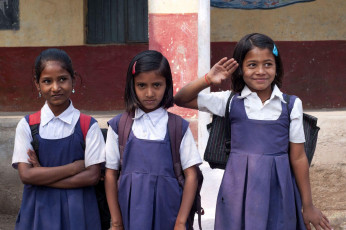 Indian girl students smile and salute as they pose for the picture, standing in their school in Rajasthan, India © CRSHELARE