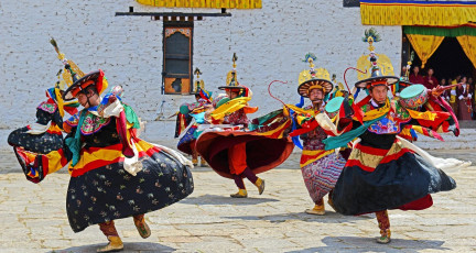 Monks perform religious dances during the popular Paro Tsechu Festival in Bhutan, Land of the Thunder Dragon. The celebrations are held at Paro Dzong, one of the prime examples of Bhutanese architecture © Samrat35