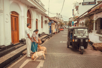 A local couple walk their dog past a tuk-tuk in the old fortified city of Galle, Sri Lanka © Radiokukka