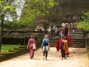 Young monks in their distinctive colored robes and visitors at the Polonnaruwa ruins. Here the second oldest kingdom in Sri Lanka was established © DavorLovinic