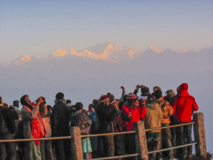 A gigantic view of Himalayas at dusk where tourists on a hiking trail look at the Himalayas in Darjeeling, India.© amlanmathur