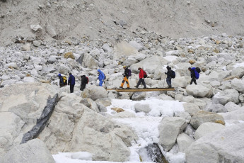 Trekkers walk along the rocky trail across a frozen river on their way to the Everest Base Camp near Lobuche in the Khumbu region. At 16,210 ft./4940 m above sea level, this settlement is one of the last overnight stops available to hikers © yai112