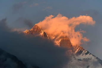 The peaks of the Lhotse Mountain emerge from the clouds, catching the late afternoon rays of the sun at Dingboche, a popular stopover for trekkers to spend a day or two acclimatizing to the altitude before they continue on to the Everest Base Camp © Jaturapat Suasongsin
