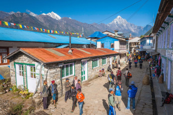 Sherpa mountain guides, Nepali porters and trekkers in the main street of Lukla, a busy little village in the Himalayan Mountains. There are a number of lodges catering for trekkers and tourists, as well as shops selling trail supplies © fotoVoyager