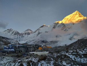Gorak Shep blends in with the snowy Himalayan mountains that surround the village. Trekkers are silhouetted against the shadows as they watch the beautiful sunset © Andrey Rykov