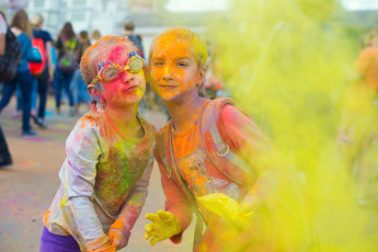 Two kids on holiday with their families have fun with colorful powder during the Holi festival. © Natalia Deksbakh / Shutterstock