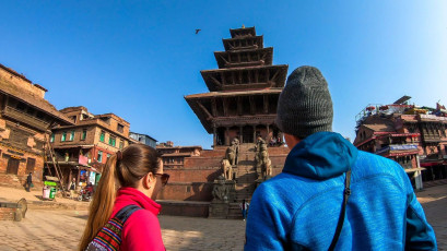 A tourist couple approaching the Nyatapola Temple on Taumadhi Square in Bhaktapur, Nepal. This five tiered temple is the tallest in Nepal. Constructed of wood and brick with magnificent carvings it is a place of spirituality and devotion for people from wide and far © Christopher Moswitzer