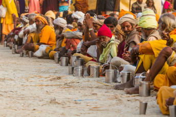 A large number of Hindu Sadhus are waiting during the Kumbh Mela festival with their utensils for the distribution of free food in Haridwar, India © Nila Newsom
