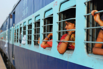Passengers looking outside from the train which is the Indian railway. It is the fourth largest railway network in the world by size and known as the "transport lifeline of the nation", India © Shukri