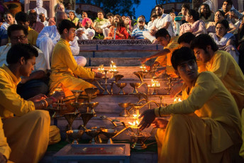 Priests lightning multiple oil lamps at the Ganga Aarti ceremony in the Parmarth Niketan Ashram which is being done on the banks of the Ganges to Mother Ganga, India © Markus Gebauer
