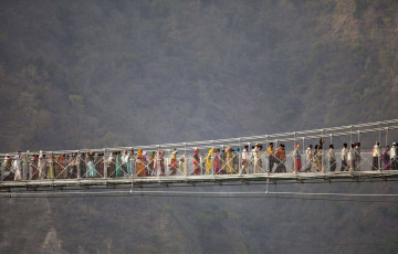 A huge crowd of Hindu pilgrims crosses the Lakshman Jhula Bridge which is an iron suspension bridge over the holy river Ganga at Rishikesh,
India © ozgurdonmaz