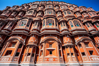 A grand view of the Hawa Mahal which is also known as the Palace of the Winds is an extraordinary pink-painted, delicately honeycombed hive shape building that rises a dizzying five storeys in Jaipur, Rajasthan, India © Pikoso.kz