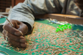 An artisan performing the task of embroidering a piece of cloth in the traditional Indian way with the use of golden thread, Zardosi embroidery that came to India from Persia, Agra. © PI