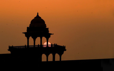 A mesmerising view of sunset adding to the beauty of Silhouette of Fatehpur Sikri - court palace with tombs. It consists of fascinating buildings made of red sandstone with some lovely, unusual carvings, India. © thipjang