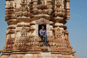 A visitor sits in a window of the intricately carved 12th century Kirti Stambha or Tower of Fame in Chittorgarh Fort. A narrow staircase leads up the seven stories to an observation area at the top which offers spectacular views of the surroundings