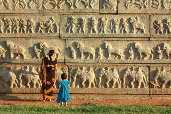 A pair of mother and child appreciate the Stone relief carvings at Hampi, the centre of the Hindu Vijayanagara Empire.