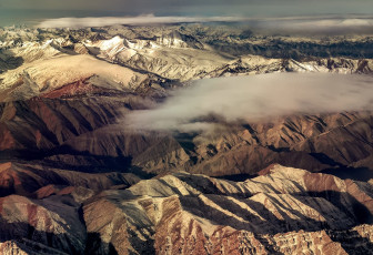 Breathtaking view of the Himalayan Mountains from onboard the morning flight between Leh and New Delhi © Spunkeeh