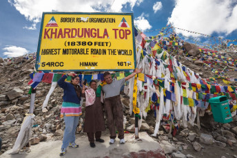 Hundreds of prayer flags adorn Khardung La Pass outside Leh, with a signboard providing information about its immense altitude © Nuk2013