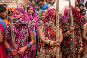In Nandgaon, India, the Lathmar Holi celebration includes women beating the menfolk with sticks playfully. © Mazur Travel / Shutterstock