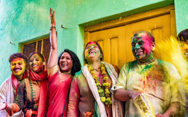 The happiness spread through the air as easily as colorful pain powder is evident on this Indian family's faces during Holi. © MindStorm / Shutterstock