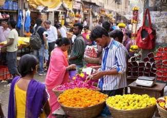 A crowded affair captured at the colorful flower market with a tiny, narrow lane lined with kiosks, stalls and even wooden planks in Mumbai, Maharashtra, India © monotoomono