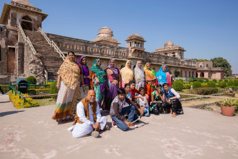 A group of visiting tourists pose for the camera in front of the Jahaz Mahal, also called the Ship Palace in Madhya Pradesh. The reflection of the building in the surrounding reservoir resembles the image of a giant ship