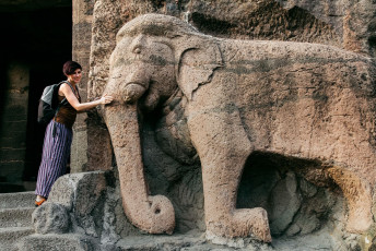 A tourist admires the stone sculpture of an elephant at the Ajanta Caves near Aurangabad. The group of around 30 rock-cut caves has some of the best examples of ancient Indian paintings and sculptures