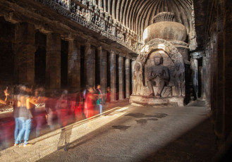 A Buddha statue basks in the sunlight in one of the narrow rectangular worship halls with its trademark high curved ceilings at the Ajanta Cave Complex near Aurangabad
