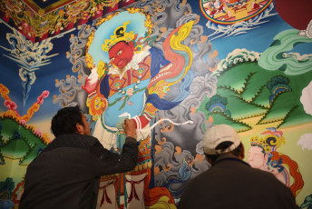 Two painters paint a colorful intricate Buddhist paintings on a huge wall in the Hemis Gompa in Leh © Tassapon