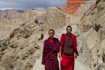 Two young Buddhist monks dressed up in their traditional attire; pass a mountain range in Leh, North India © Sergemi