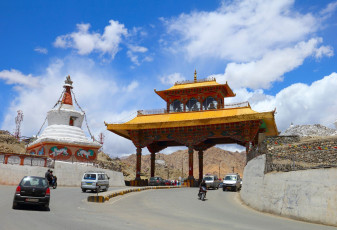 A Buddhist style gate standing tall with a beautiful city view in the backdrop in Leh, Ladakh, Jammu & Kashmir, India © Natalia Davidovich