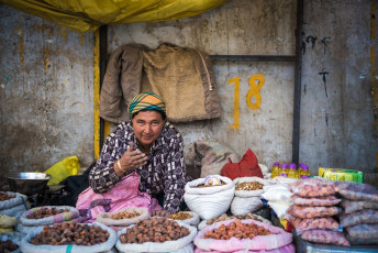 A woman wearing woolen clothes sells vegetables and food items on the market street in Leh-Ladakh, India. This cold desert is known for its mesmerizing views and unique culture © Panom
