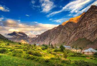 Fields of green contrast beautifully with the rugged mountains of the Lahaul Valley, Himachal Pradesh. The village of Jispa nestles at the foot of the mountains © structuresxx