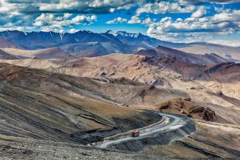 A scenic view of Leh-Manali Highway where an Indian truck rides on the road in the Himalayas near the Tanglang La Pass in Ladakh, India © f9photos