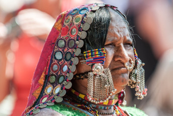 A beautiful portrait of a Lamani woman dressed in a total traditional attire with ornaments at the well known Anjuna flea market in North Goa, India © AndreaObzerova