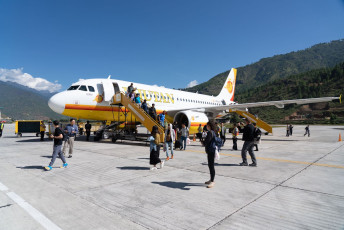 1.	Visitors arrive in a Bhutan Airlines airplane at the Paro International Airport. Only a small number of pilots are qualified to land here, due to the high mountain peaks surrounding the airport © charnsitr