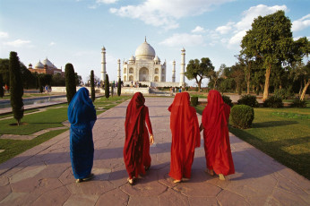 Indian women walk towards the spectacular Taj Mahal which is surrounded with green gardens, Agra, Uttar Pradesh, India © oversnap
