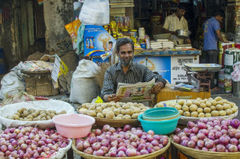 A vegetable seller sells fresh produce, onions and potatoes on the streets at a local market in Old Delhi, India. © Pete Burana