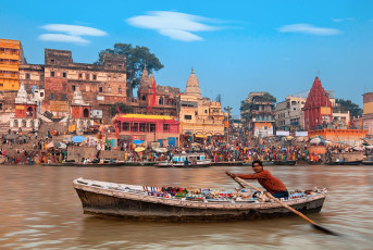 A boatman rows his merchandise on the Ganges River past one of Varanasi’s 88 holy ghats © Lena Serditova