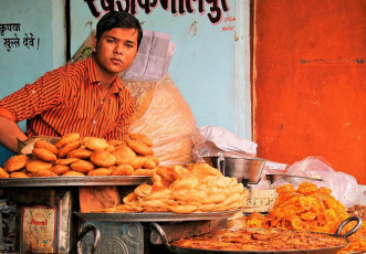 A seller at a local snack shop in Jaipur selling jalebis, pooris, kachoris, and more. @ Neale Cousland