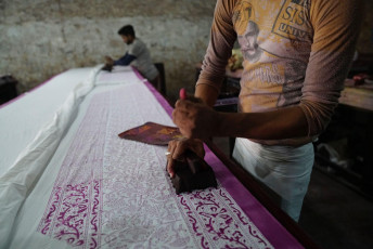 Block printing on fabrics is an old tradition in Rajasthan. Here artisans are working on a long piece of fabric in a textile dyeing shop - Photo By  Wang Sing