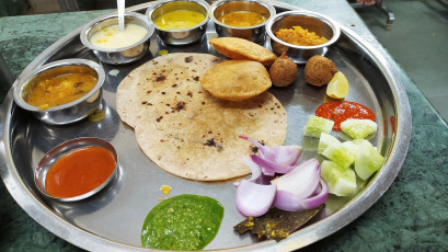 The delicious Maharaja thali is served on a large round platter and consists of flatbread, lentils, vegetables and chutney. Rajasthan is famous for its delicious thalis - Photo By Harshit Srivastava S3