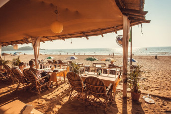 Tourists enjoying a meal at a beach restaurant in Goa. The state is famous for its pristine beaches and has an extensive coastline - Photo By  Radiokafka