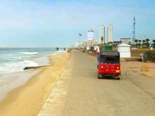 Oceanside promenade along Galle Face Beach with the Colombo skyline in the background, Sri Lanka © donyanedomam