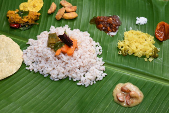 Traditional food of Kerala served on a banana leaf from cooked rice to buttermilk to chips in India. © Santhosh Varghese