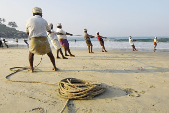 A group of fishermen try to pull their nets out of the sea at Kovalam Beach in Kerala. Fishing is not just a livelihood for the locals but also turned out to be an excellent tourist-bait throughout Kerala, India. © Vlad Karavaev